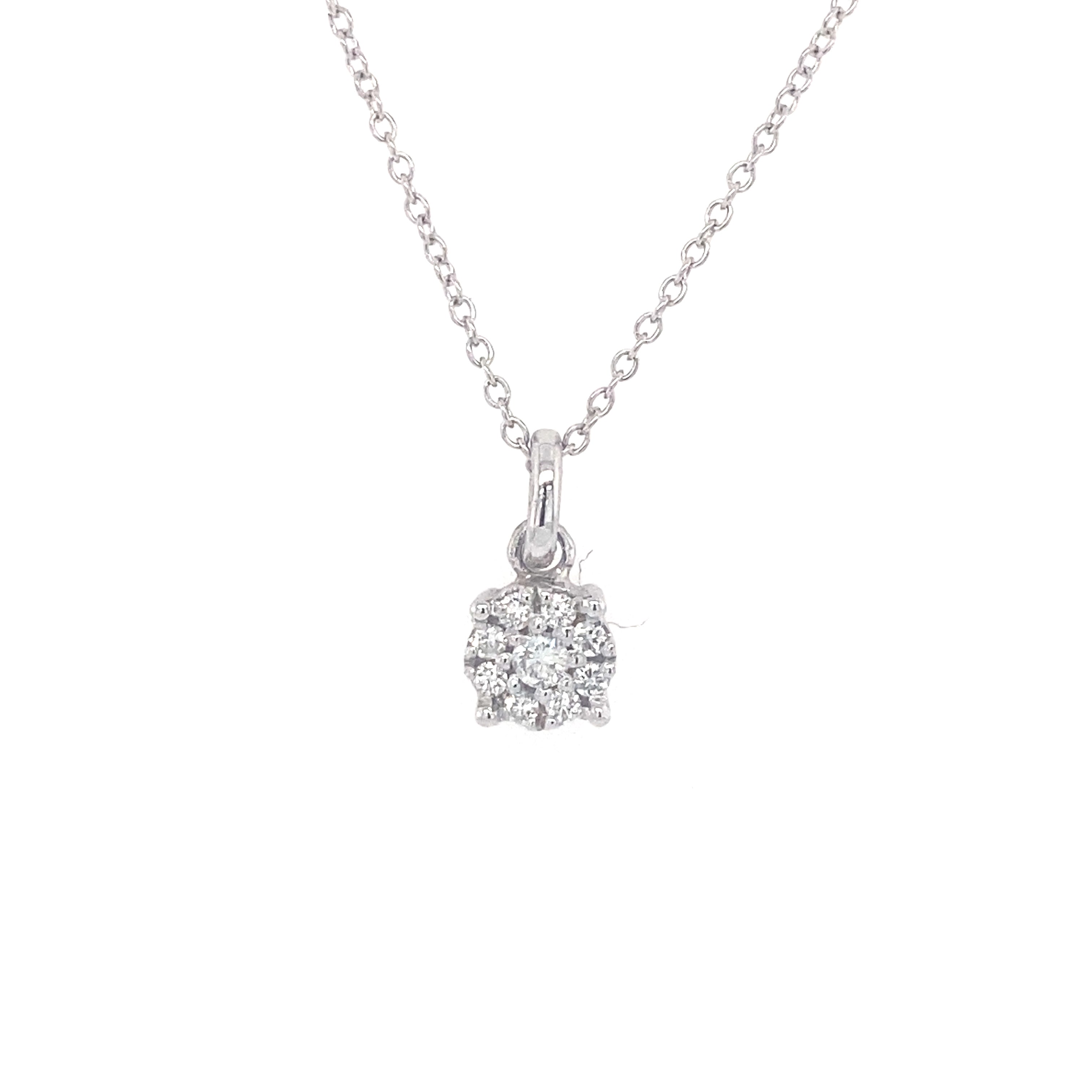 close up of white gold diamond illusion pendant on a white background