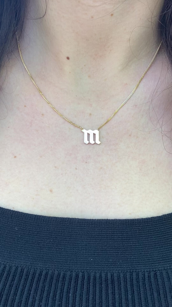 Fashionable gold curb necklace with Gothic initial, great for personalized style.