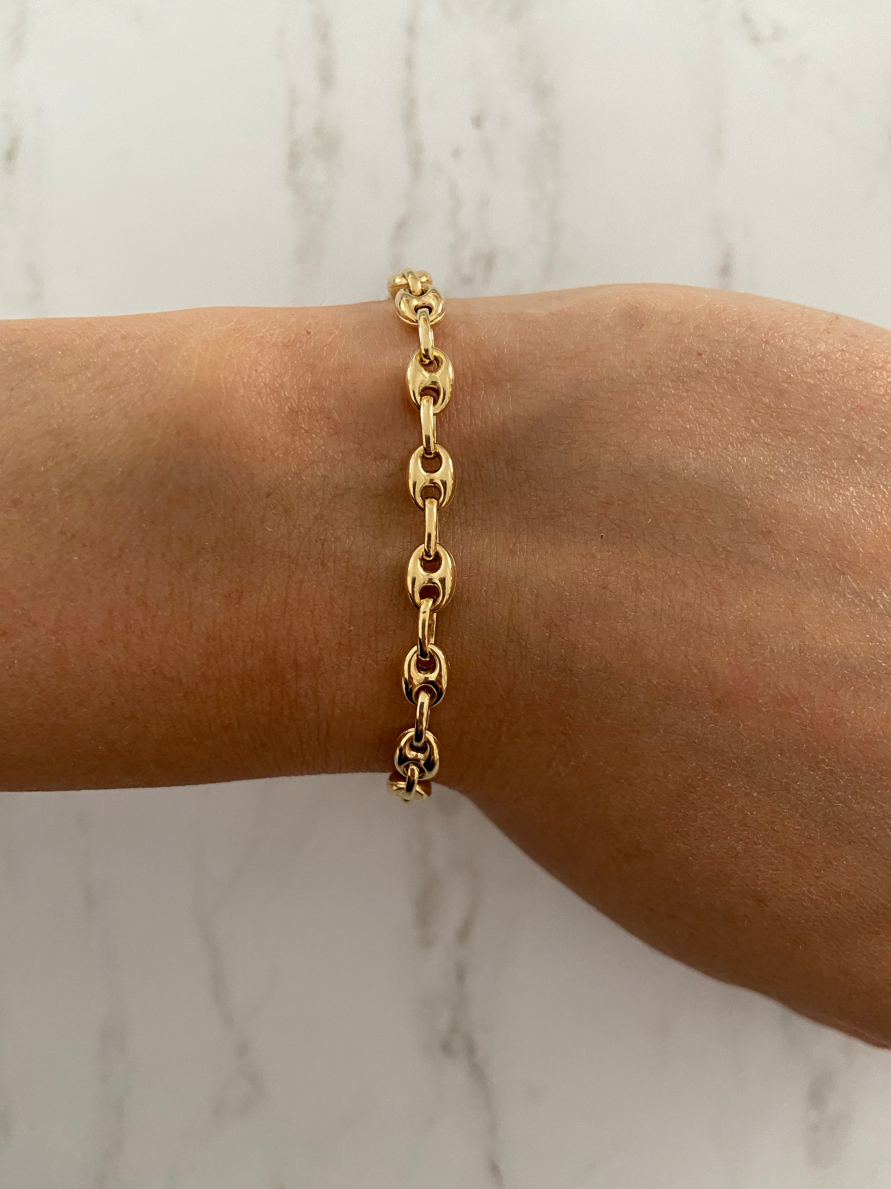 Gold puffed anchor bracelet worn solo on arm