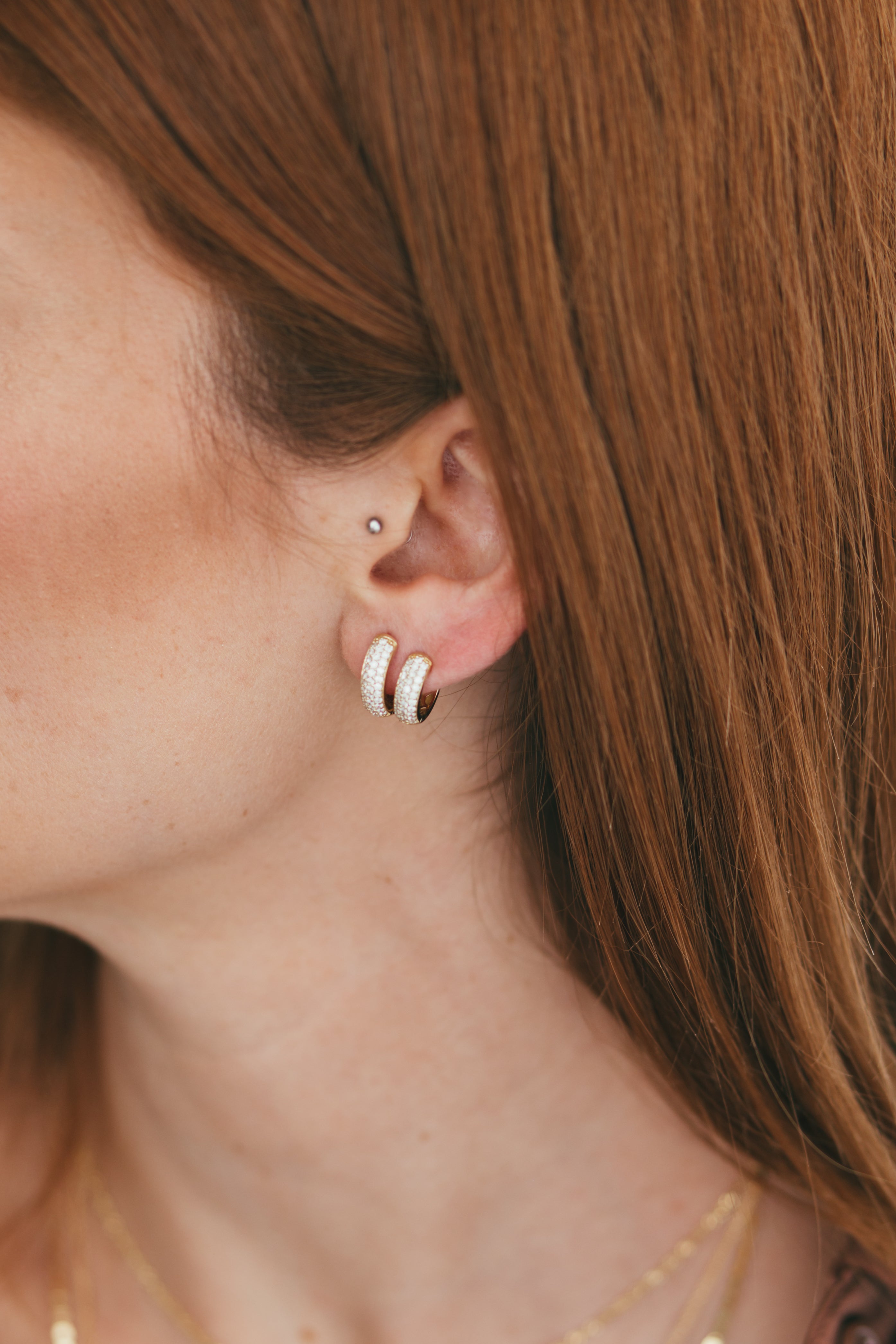 Elegant display of Domed Diamond Pave Huggies on model