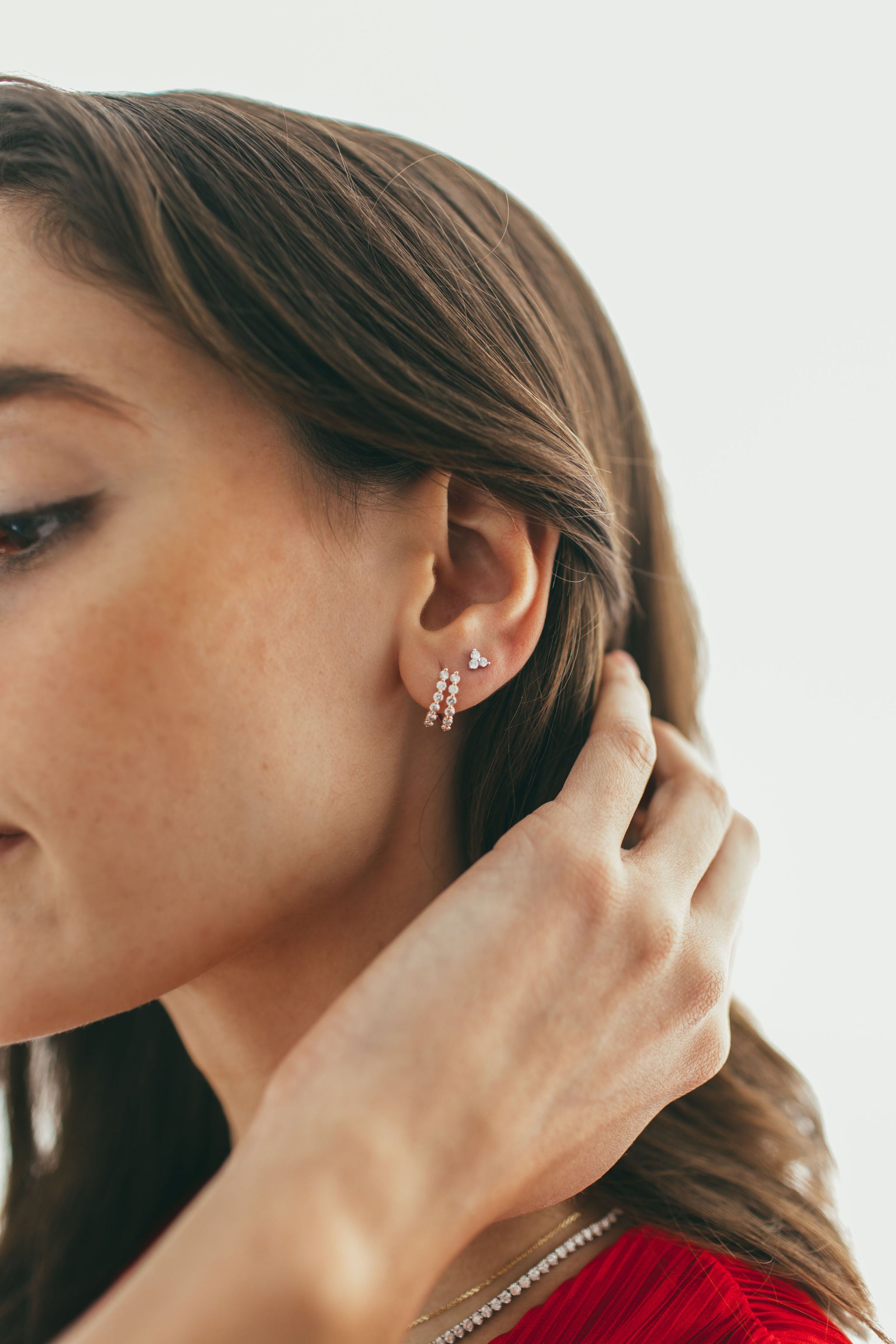close up of ear wearing large rose gold single prong double diamond huggies