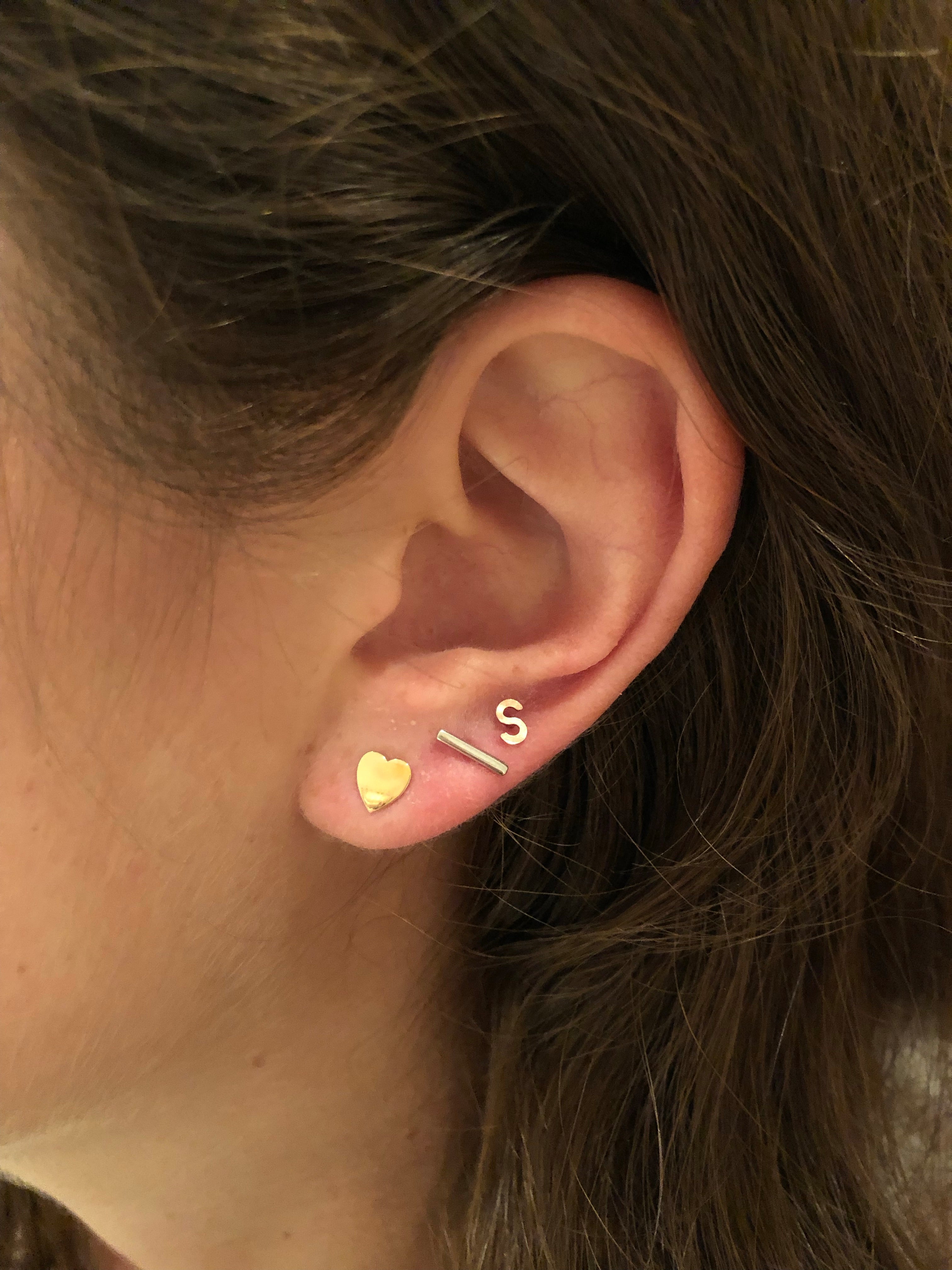 close up of ear wearing multiple studs