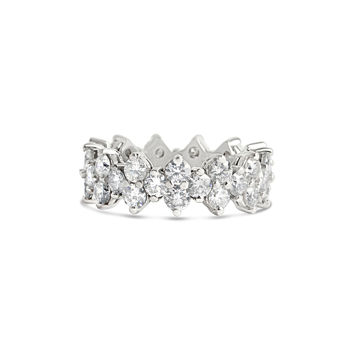 A close up of a striking white gold multi diamond eternity band on a white background.