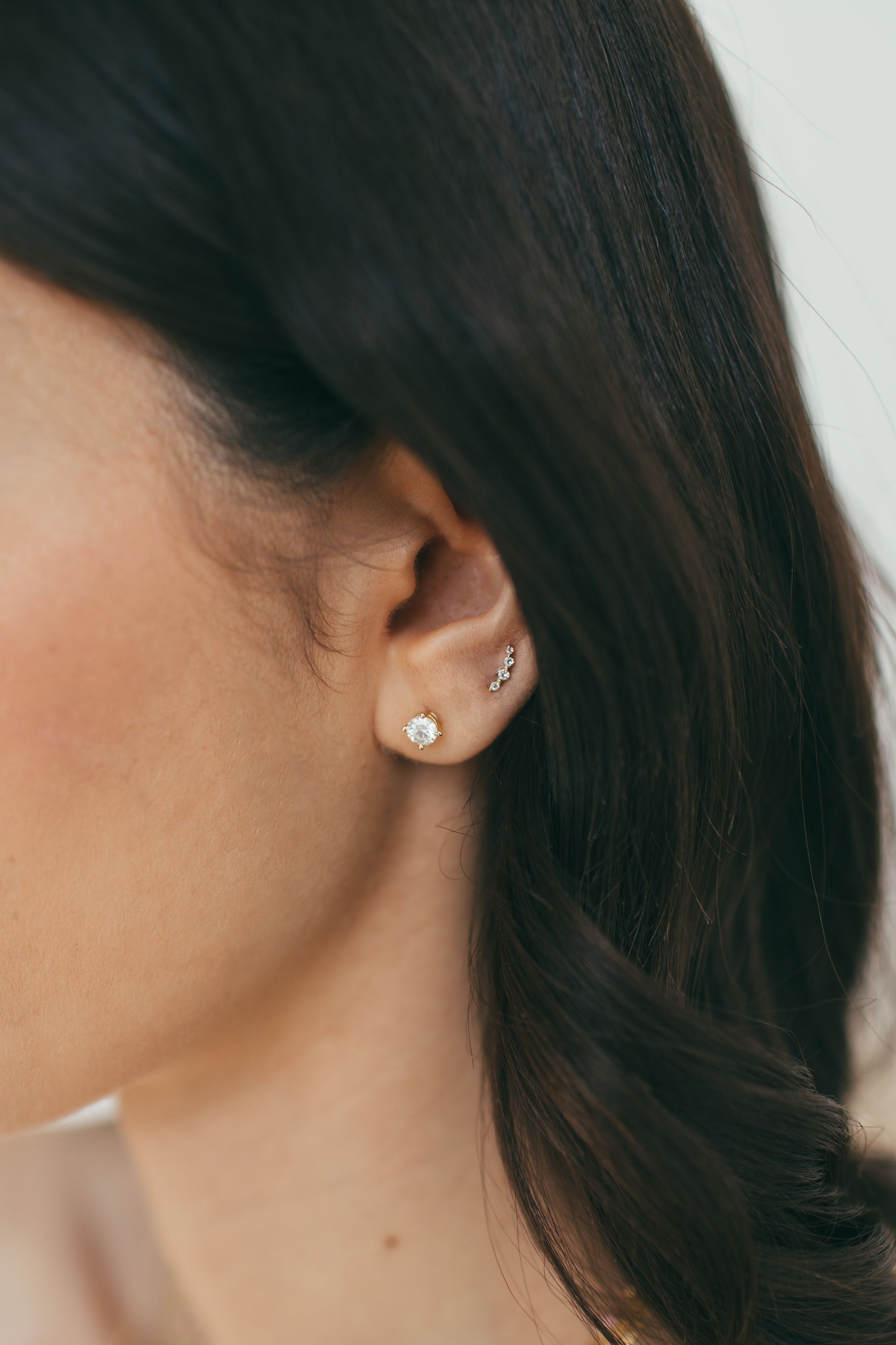 close up of girls ear wearing white gold natural diamond earrings