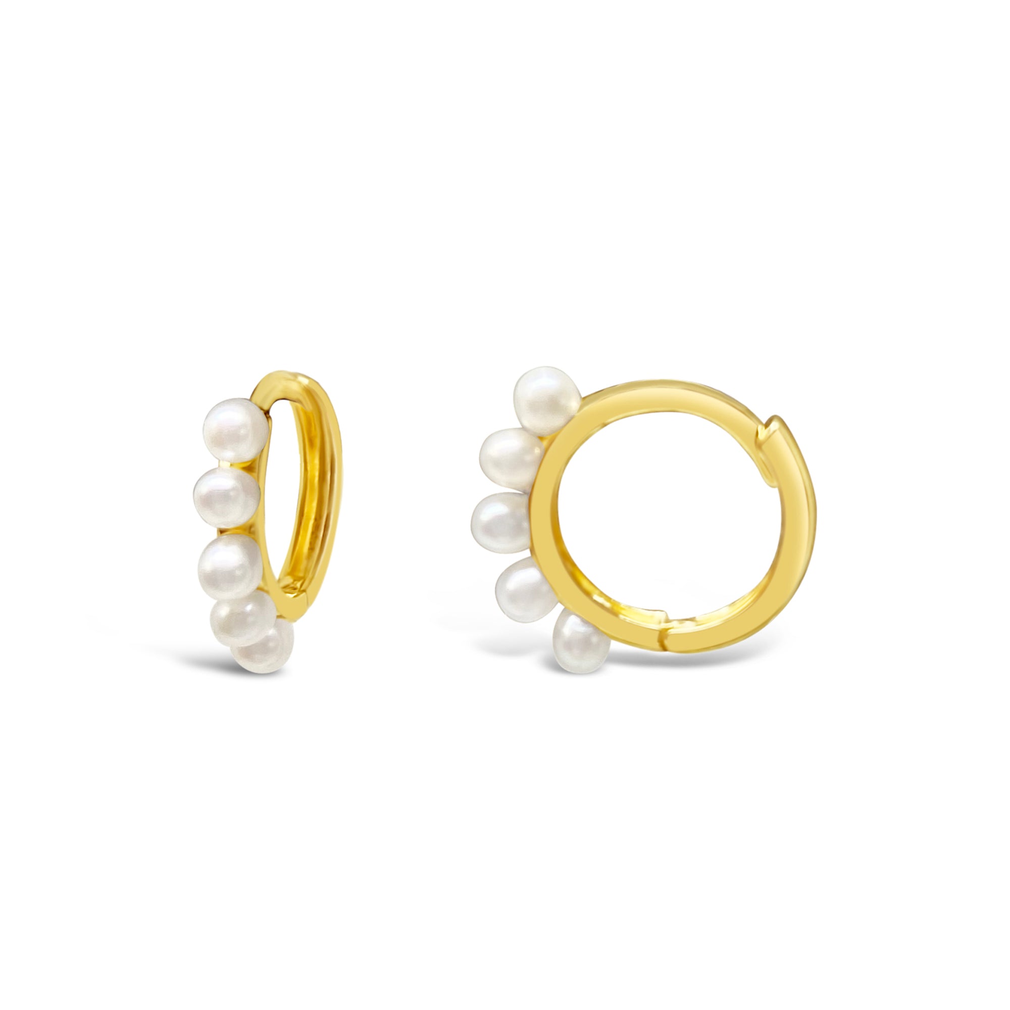 A pair of gold huggie earrings with freshwater pearls attached to them, displayed against a white background.