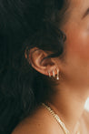 Luxurious diamond huggie earrings with pear drop showcased on model.