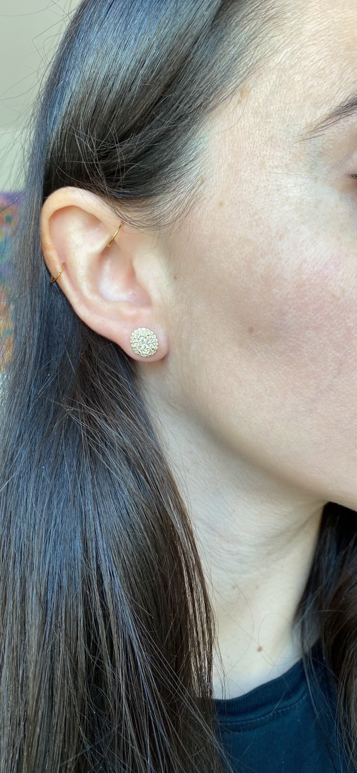 close up of ear wearing large oval shaped diamond cluster studs
