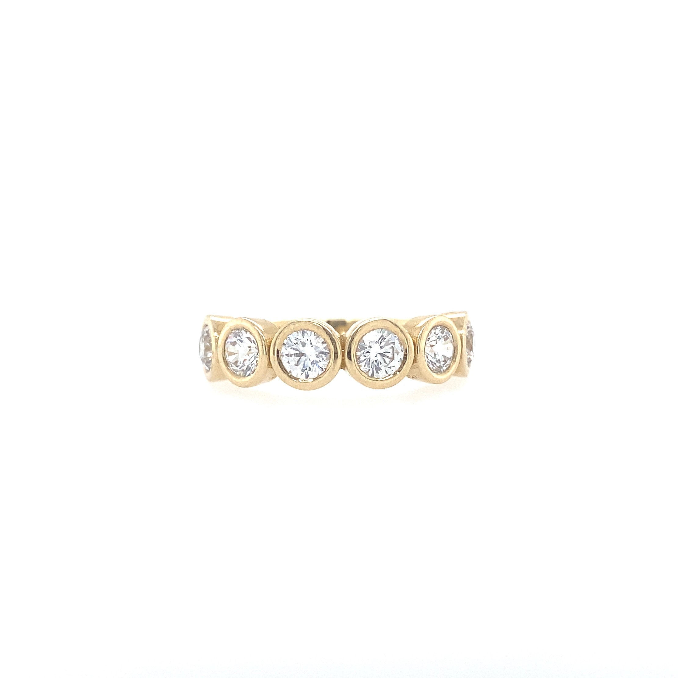 A gold diamond bezel ring with multiple stones arranged in a circle pattern.
